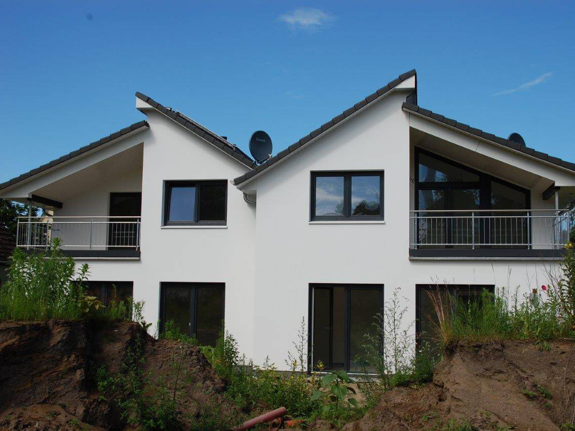 Ein Doppelhaus mit überdachtem Balkon / Terrasse - so schön kann Bauen mit dem AMBIENTE Bauunternehmen sein